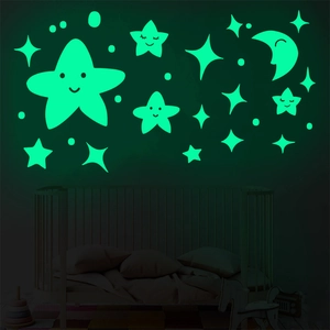 Glow in the dark wall stickers featuring smiling stars and moon in a dark bedroom