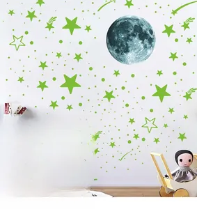 Detailed view of glow in the dark moon and star wall stickers on a white bedroom wall
