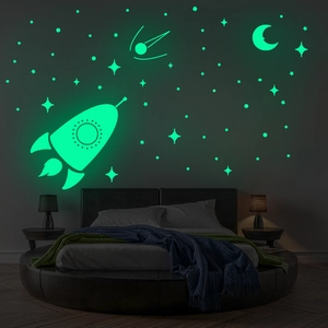 Stickers muraux lumineux avec fusée, lune et étoiles dans une chambre d'enfant sombre