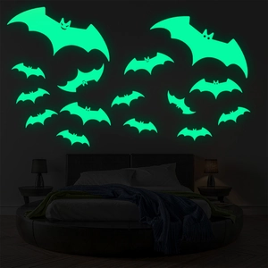 Glow-in-the-dark Halloween bat wall stickers showing fluorescent green light in a dark bedroom