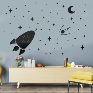 Detail of black acrylic spaceship and moon wall stickers on light blue wall in modern room
