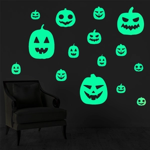 Detailed view of fluorescent green glow in the dark pumpkin face wall decals at night