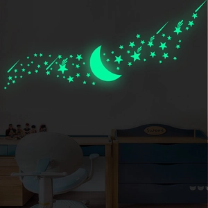 Luminous wall sticker set featuring stars and moon glowing in green light in kids bedroom