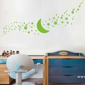 Luminous green star and moon wall stickers glowing in a clean children's bedroom setting