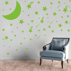 Detail view of luminous star and moon wall stickers on a modern grey wall with chair