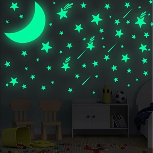 Luminous moon and stars wall stickers glowing bright green in a dark children bedroom