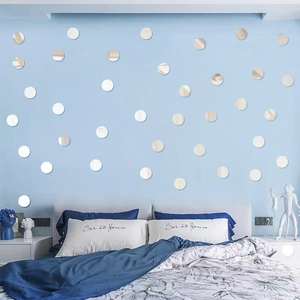 Close-up of circular acrylic mirror wall stickers on a light blue bedroom wall