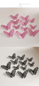 Gros plan des stickers muraux papillons 3D ajourés en finitions rose et noir mat