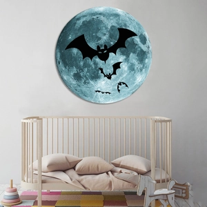 Luminous Halloween wall decal featuring a blue textured moon and black bats in a nursery