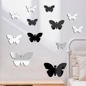 Detail of 3D mirror butterfly wall stickers in black, white, and silver on a bedroom wall