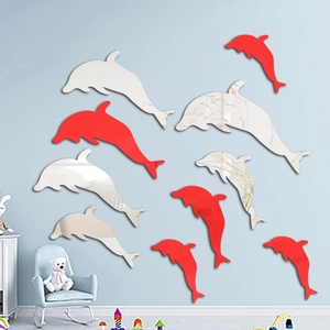 Detail of red and silver mirror dolphin wall stickers in a cozy home interior setting