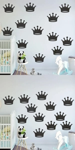 Nursery room wall detail featuring black crown wall decals above a white wooden crib