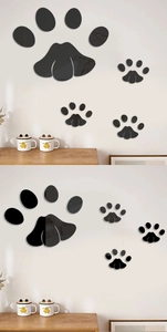 Detail of glossy black acrylic cat paw mirror wall stickers reflecting on a white wall