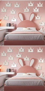 Close-up of crown-shaped acrylic mirror wall stickers on a pink nursery wall background