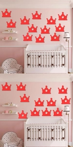 Macro shot of red acrylic crown wall stickers in a pink-themed nursery bedroom