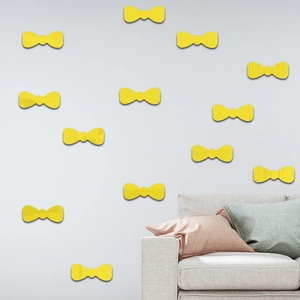 Close-up of bright yellow bow-knot mirror wall stickers on a minimalist gray living room wall