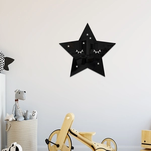 Close-up of black mirror star wall sticker with cute sleepy face for nursery wall decor