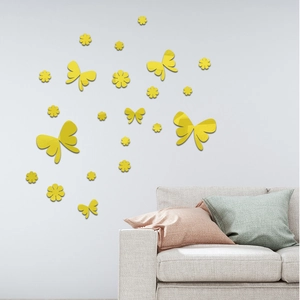 Detailed view of yellow mirror acrylic flower and butterfly wall stickers on a white wall