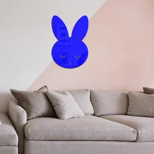 Close-up of Klein blue rabbit mirror wall sticker with gold eyelashes on a modern wall