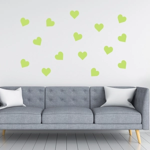 Leuchtende Herz-Wandtattoos in Neongrün über einem modernen Sofa als Schlafzimmerdeko