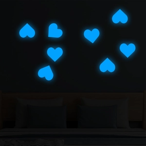 Luminous blue heart-shaped wall stickers glowing on a dark bedroom wall for kids room