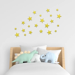 Détail de stickers muraux étoiles jaunes disposés sur un mur blanc dans une chambre d'enfant
