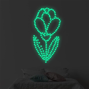 Stickers muraux cœurs phosphorescents formant une tulipe sur un mur sombre