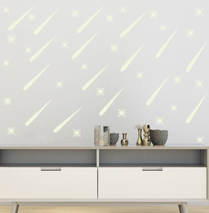 Detail showing glowing meteor and star wall decals on a modern minimalist living room wall