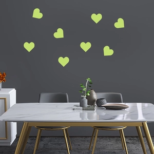 Luminous green heart wall stickers glowing on dark grey interior wall with dining setup