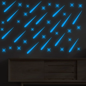 Detailed view of luminous blue star and meteor wall stickers glowing in a dark room