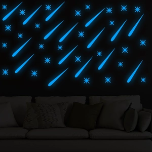 Luminous wall stickers showing blue fluorescent stars and meteors in a dark living room