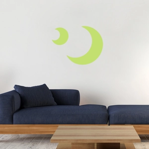 Detailed view of luminous green moon wall decals above a blue sofa in a cozy kids room