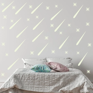 Detailed view of glowing meteor and star wall decals on a minimalist bedroom background