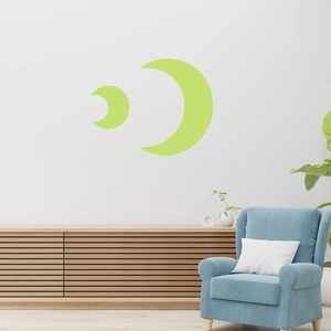 Detailed view of light green glow-in-the-dark moon wall stickers in a minimalist room