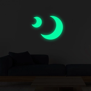Luminous crescent moon wall stickers glowing bright green in a dark bedroom setting