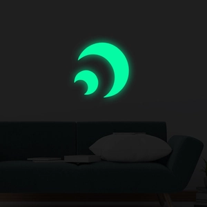 Glow-in-the-dark moon wall stickers emitting vibrant green light in a dark living room