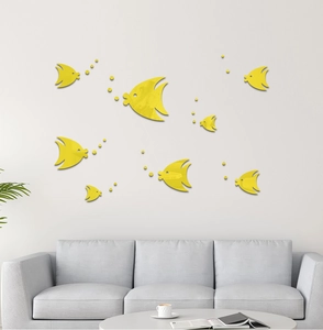 Detailed view of yellow 3D acrylic mirror fish wall stickers on a modern grey sofa wall