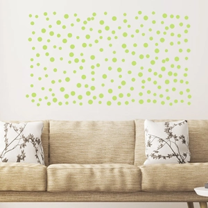 Detailed view of luminous green polka dot wall stickers in a modern living room setup