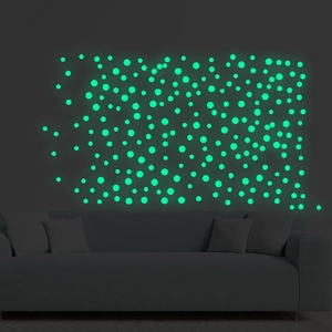Macro view of luminous round wall stickers glowing in bright fluorescent green in the dark