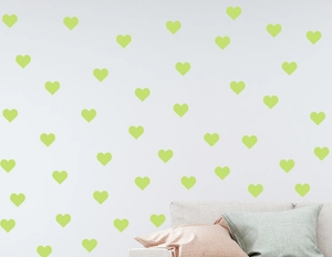 Luminous heart wall stickers in lime green arranged above a modern sofa in a living room