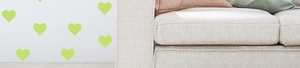 Detailed close-up of green heart glow stickers on a white wall in a modern living room