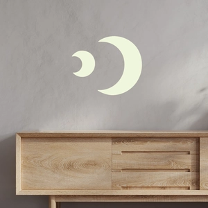 Vista dettagliata degli adesivi murali luna luminosa su una parete grigia sopra un mobile in legno