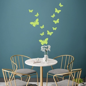 Luminous butterfly wall stickers displayed on a navy wall in a modern living room setting