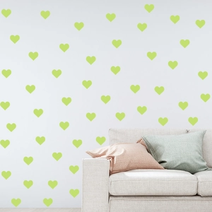 Glow in the dark heart wall stickers decorating a white wall above a cozy sofa