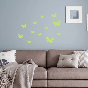 Close-up of glow-in-the-dark butterfly wall stickers on a modern grey living room wall