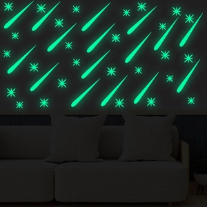 Close-up of glowing meteor and star wall stickers emitting green light in a dark room