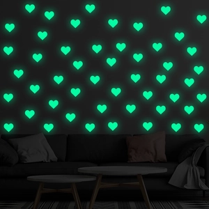 Luminous heart-shaped wall stickers glowing in green on a dark living room wall