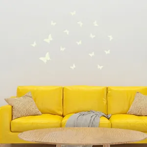 Luminous butterfly wall stickers in living room with yellow sofa and white wall decor