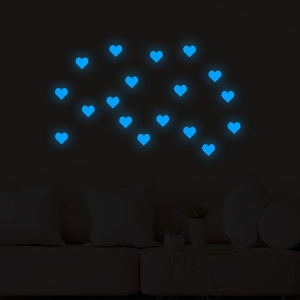 Luminous blue heart-shaped wall stickers glowing in a dark living room setting