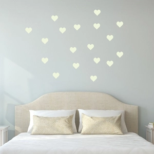 Luminous heart wall stickers creating a cozy atmosphere in a bedroom above the bed